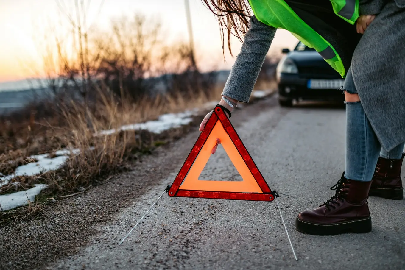 kobieta ustawia trójkąt ostrzegawczy